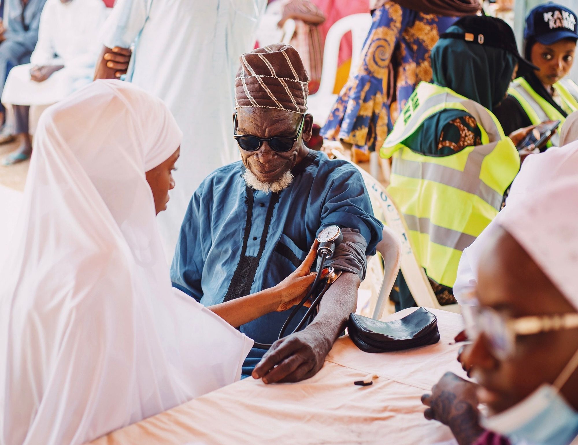 A community health worker checking a patient's blood pressure